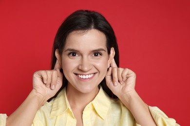 Photo of Woman showing hand to ear gesture on red background