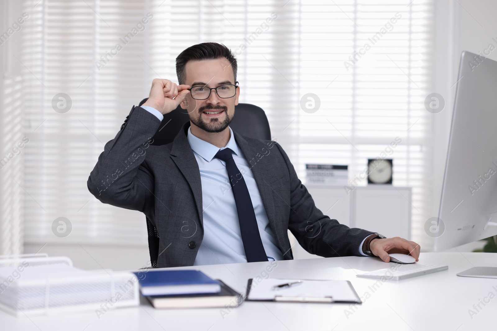 Photo of Portrait of smiling banker at table in office