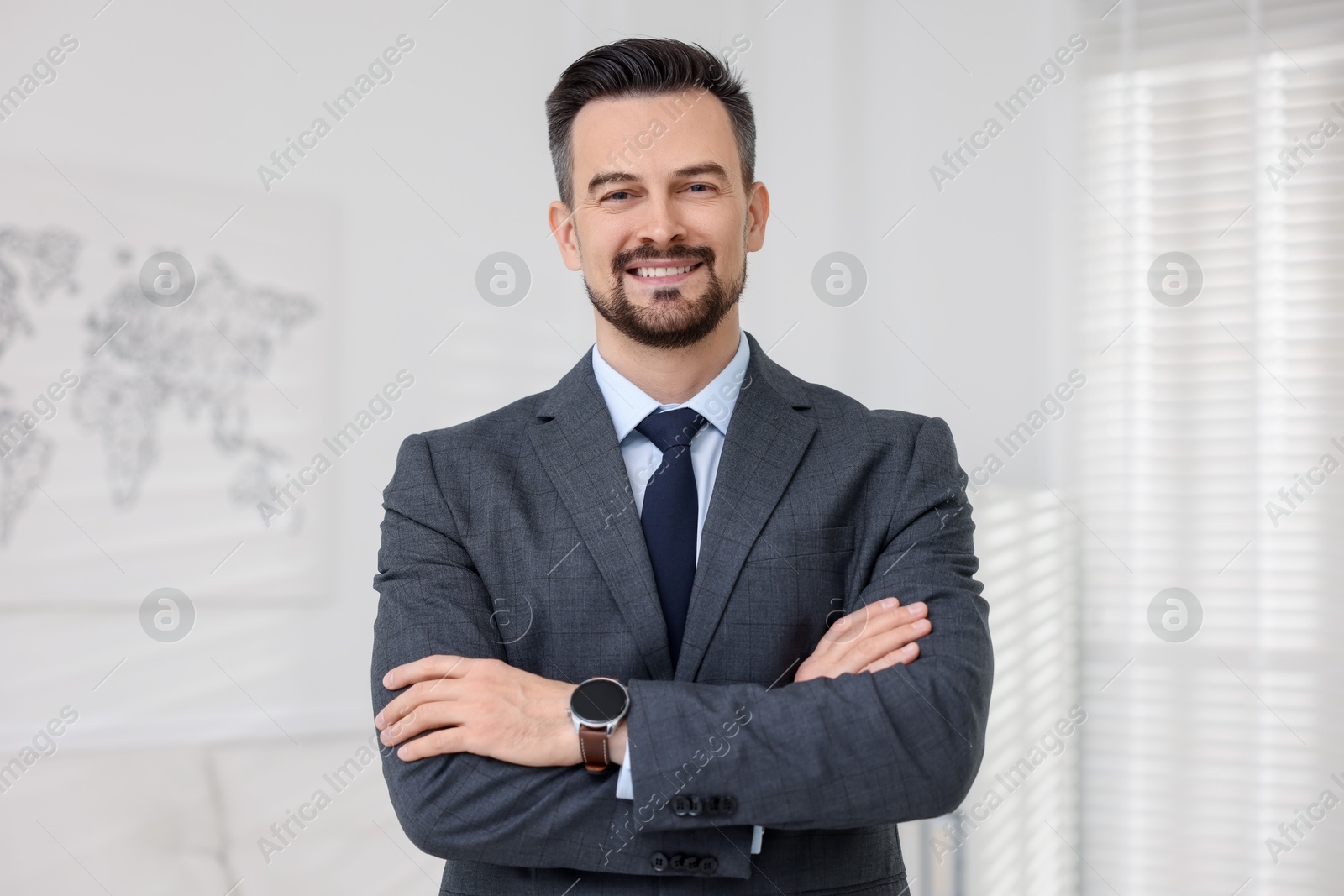 Photo of Portrait of smiling banker with crossed arms in office