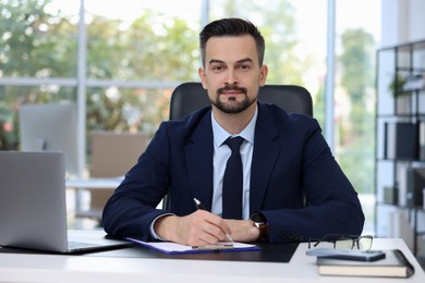 Photo of Portrait of handsome banker at table in office