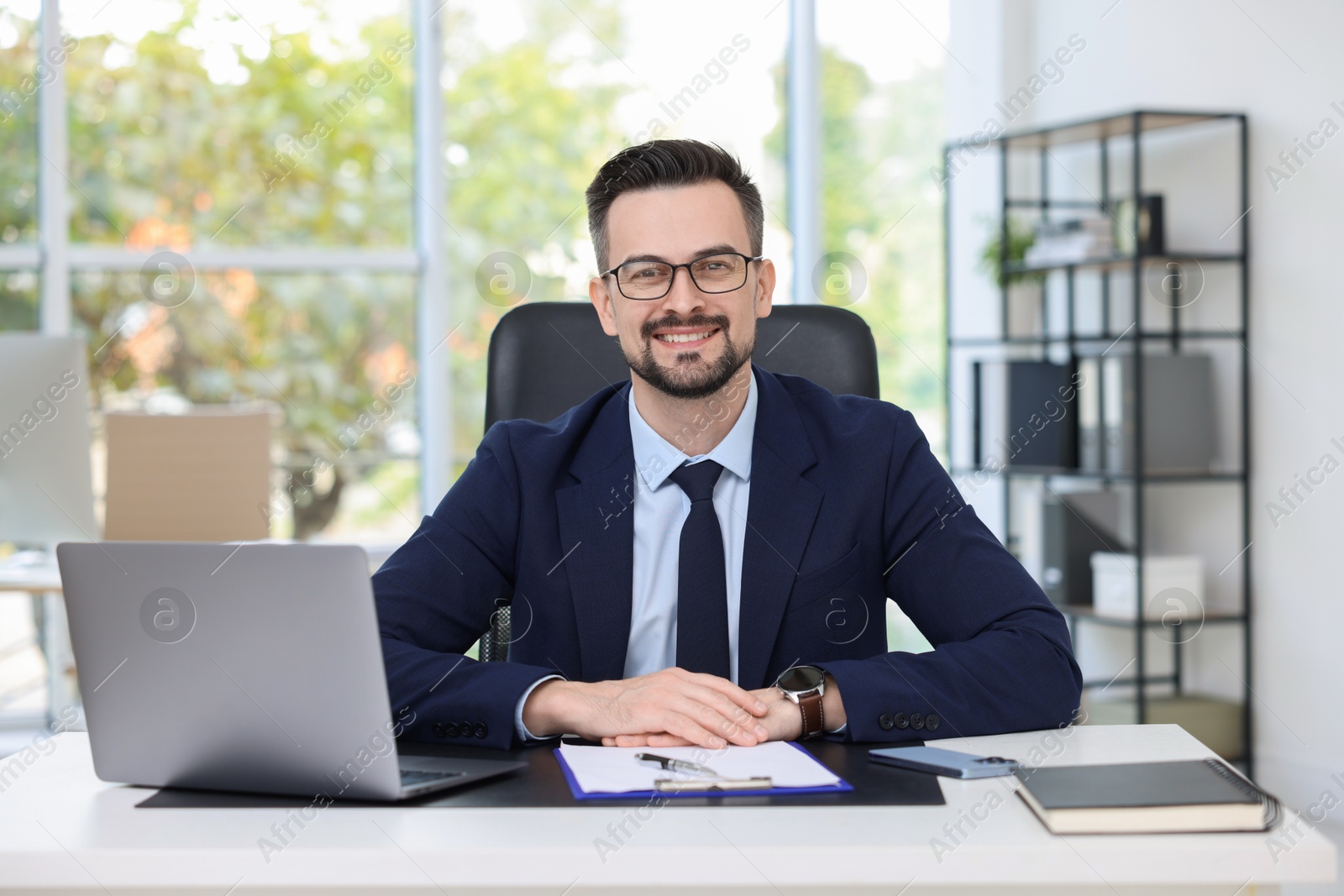 Photo of Portrait of smiling banker at table in office