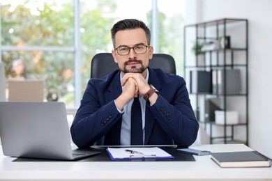 Photo of Portrait of handsome banker at table in office