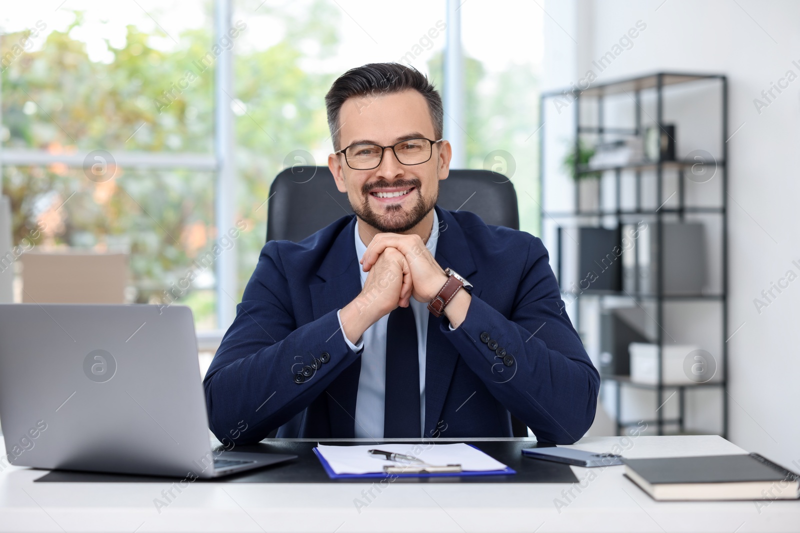 Photo of Portrait of smiling banker at table in office