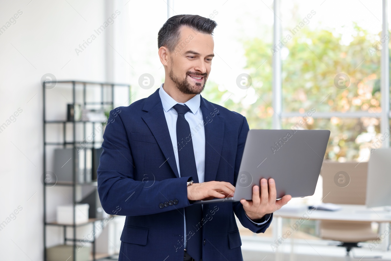 Photo of Smiling banker working with laptop in office