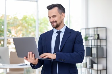 Photo of Smiling banker working with laptop in office