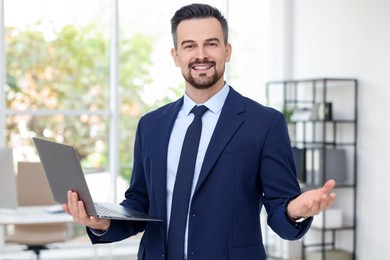 Photo of Portrait of smiling banker with laptop in office