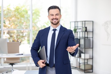 Photo of Portrait of smiling banker with laptop in office