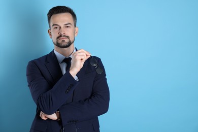 Photo of Portrait of handsome banker on light blue background. Space for text