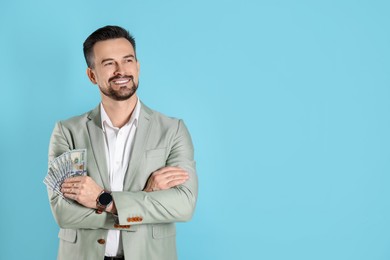 Photo of Portrait of smiling banker with dollar banknotes on light blue background. Space for text