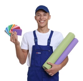 Photo of Young decorator with color palettes and rolls of wallpaper on white background