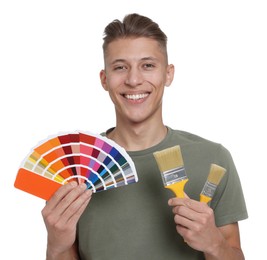 Photo of Portrait of young decorator with color palettes and brushes on white background