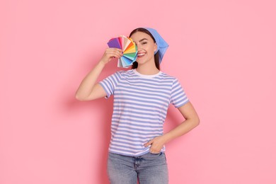 Photo of Portrait of young decorator with color palettes on pink background