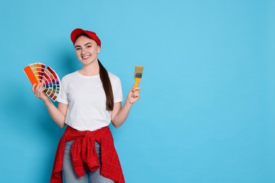 Photo of Portrait of young decorator with color palettes and brush on light blue background, space for text