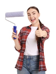 Photo of Portrait of young decorator with paint roller showing thumbs up on white background