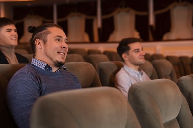 Group of people watching theatrical performance in theatre