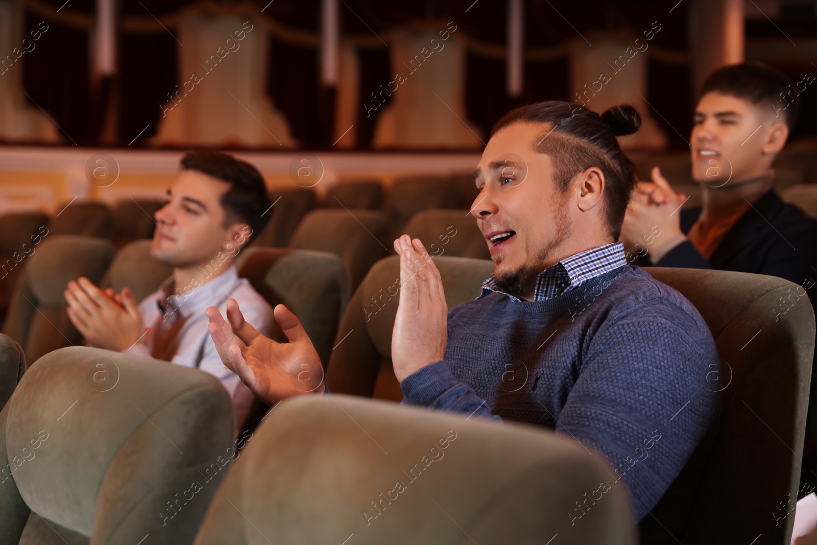 Photo of Group of exited people applauding in theatre