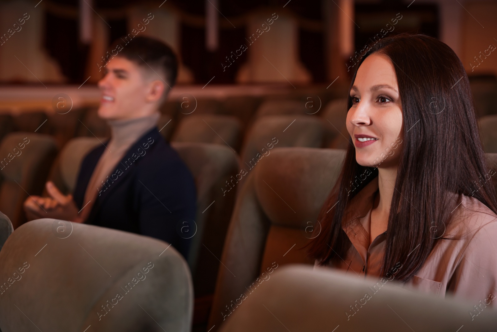 Photo of Woman and man watching theatrical performance in theatre