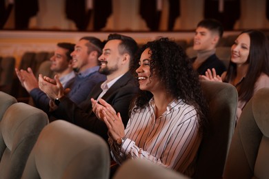 Photo of Group of exited people applauding in theatre