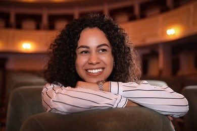 Photo of Happy woman watching theatrical performance in theatre