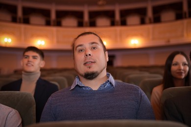 Group of people watching theatrical performance in theatre