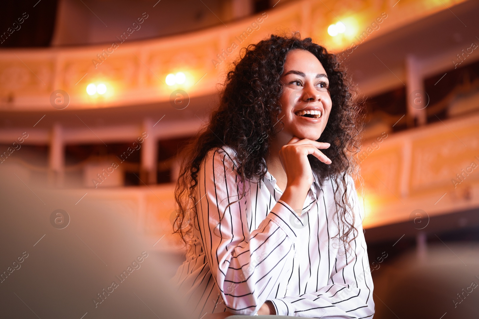 Photo of Happy woman watching theatrical performance in theatre