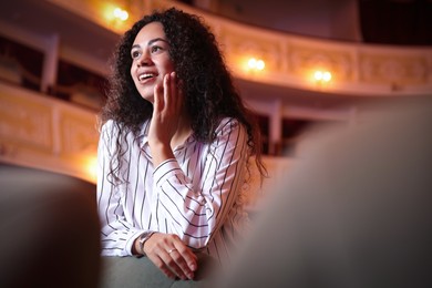 Photo of Happy woman watching theatrical performance in theatre