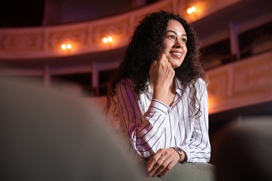 Photo of Happy woman watching theatrical performance in theatre