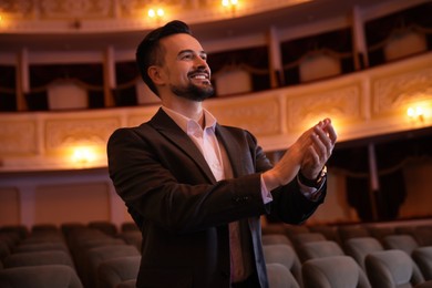 Photo of Portrait of happy man applauding in theatre