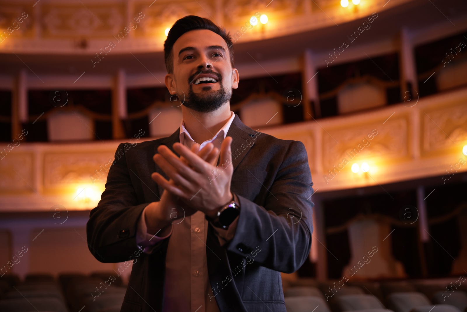 Photo of Portrait of happy man applauding in theatre