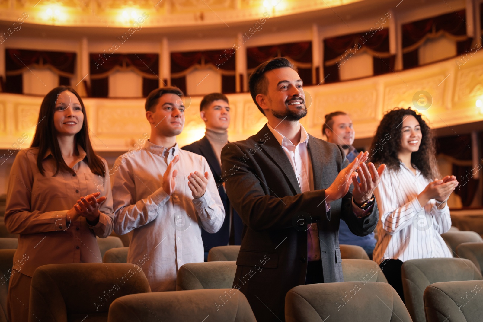 Photo of Group of exited people applauding in theatre