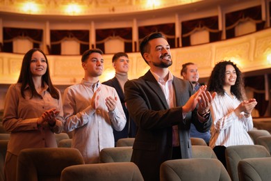 Photo of Group of exited people applauding in theatre