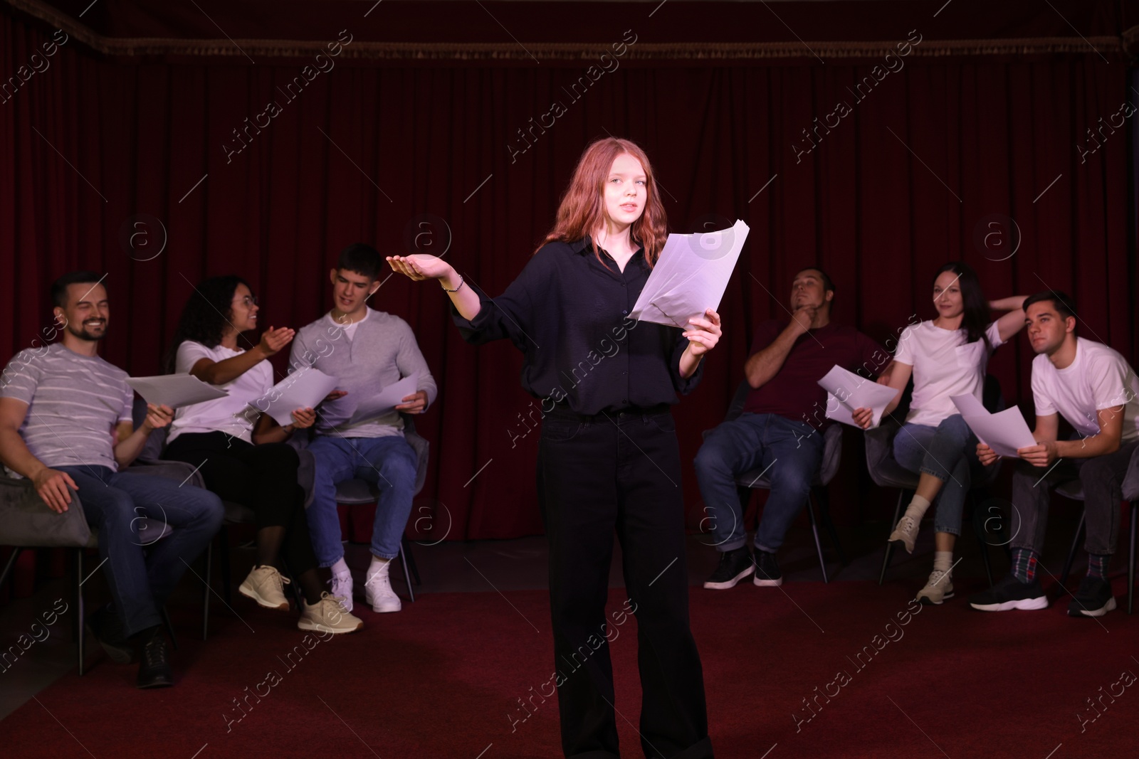 Photo of Professional actors reading their scripts during rehearsal in theatre