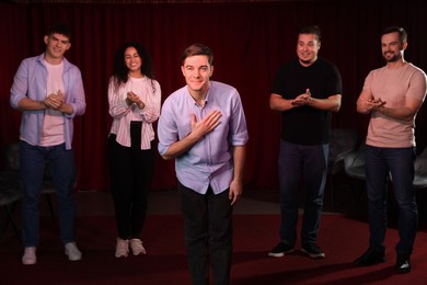 Photo of Professional actors bowing on stage in theatre