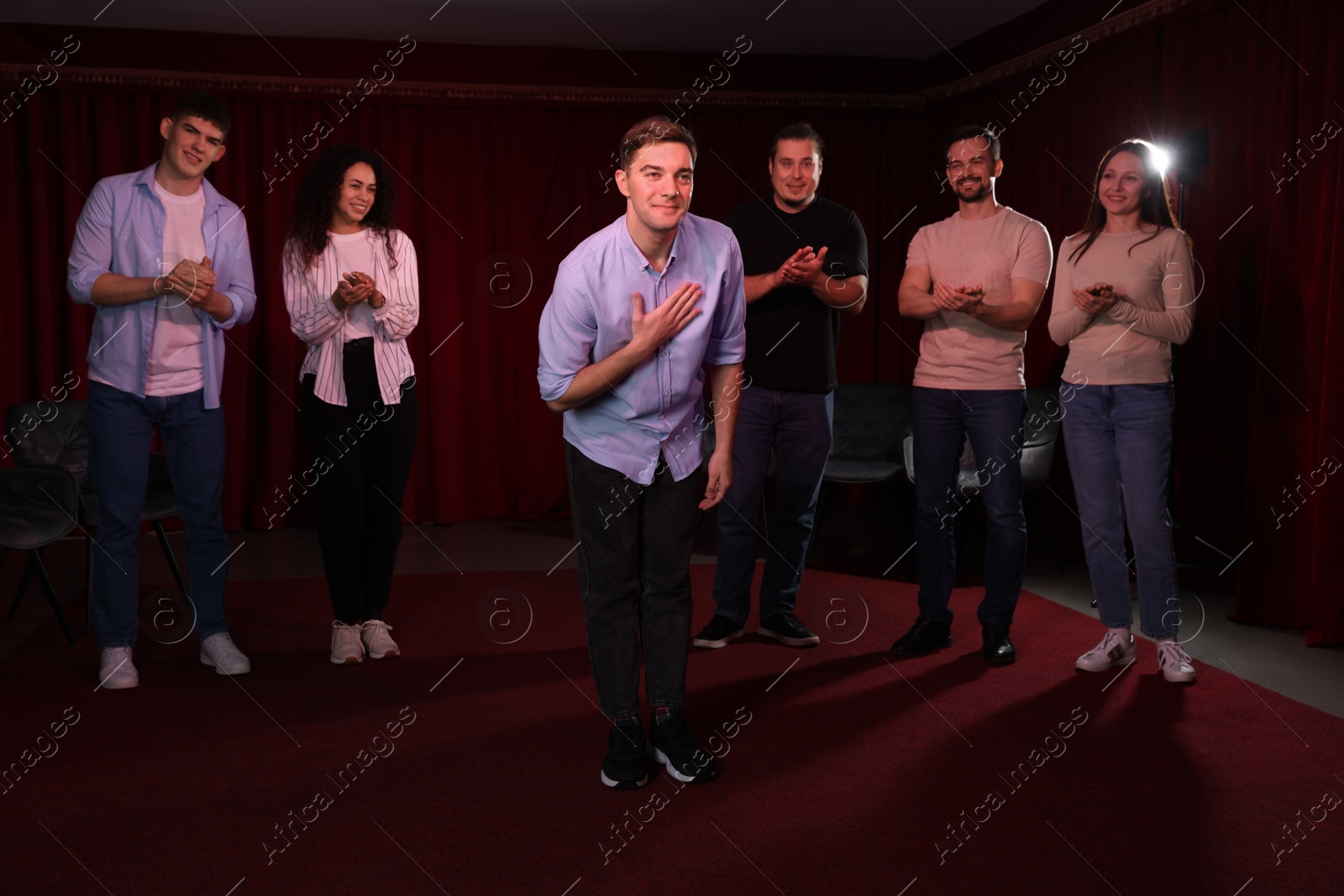 Photo of Professional actors bowing on stage in theatre