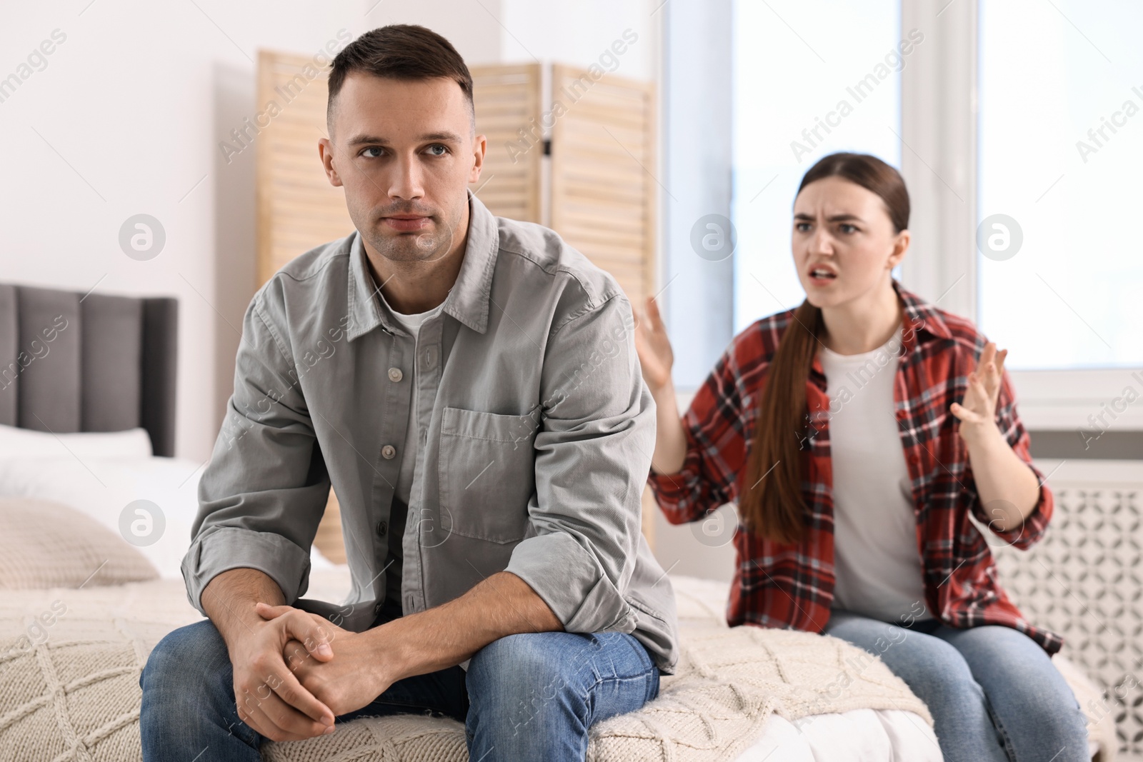 Photo of Husband ignoring his emotional wife at home, selective focus