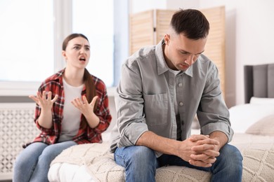 Photo of Husband ignoring his emotional wife at home, selective focus