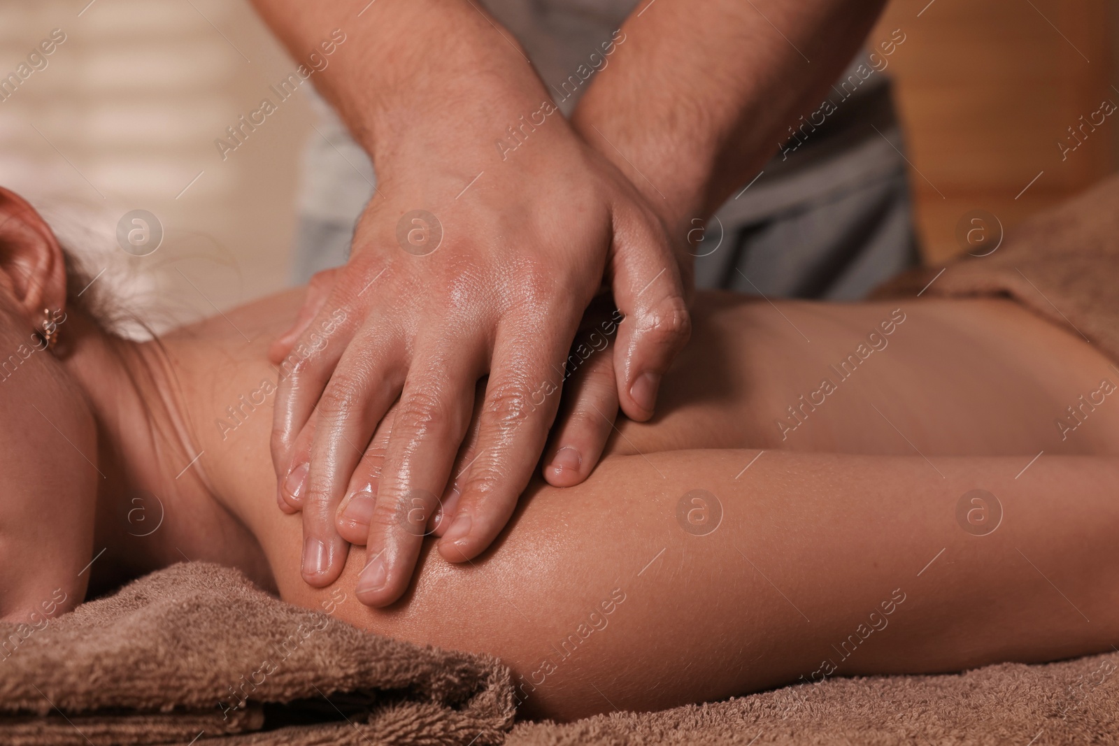 Photo of Osteopath massaging woman's back on couch indoors, closeup. Manual therapy