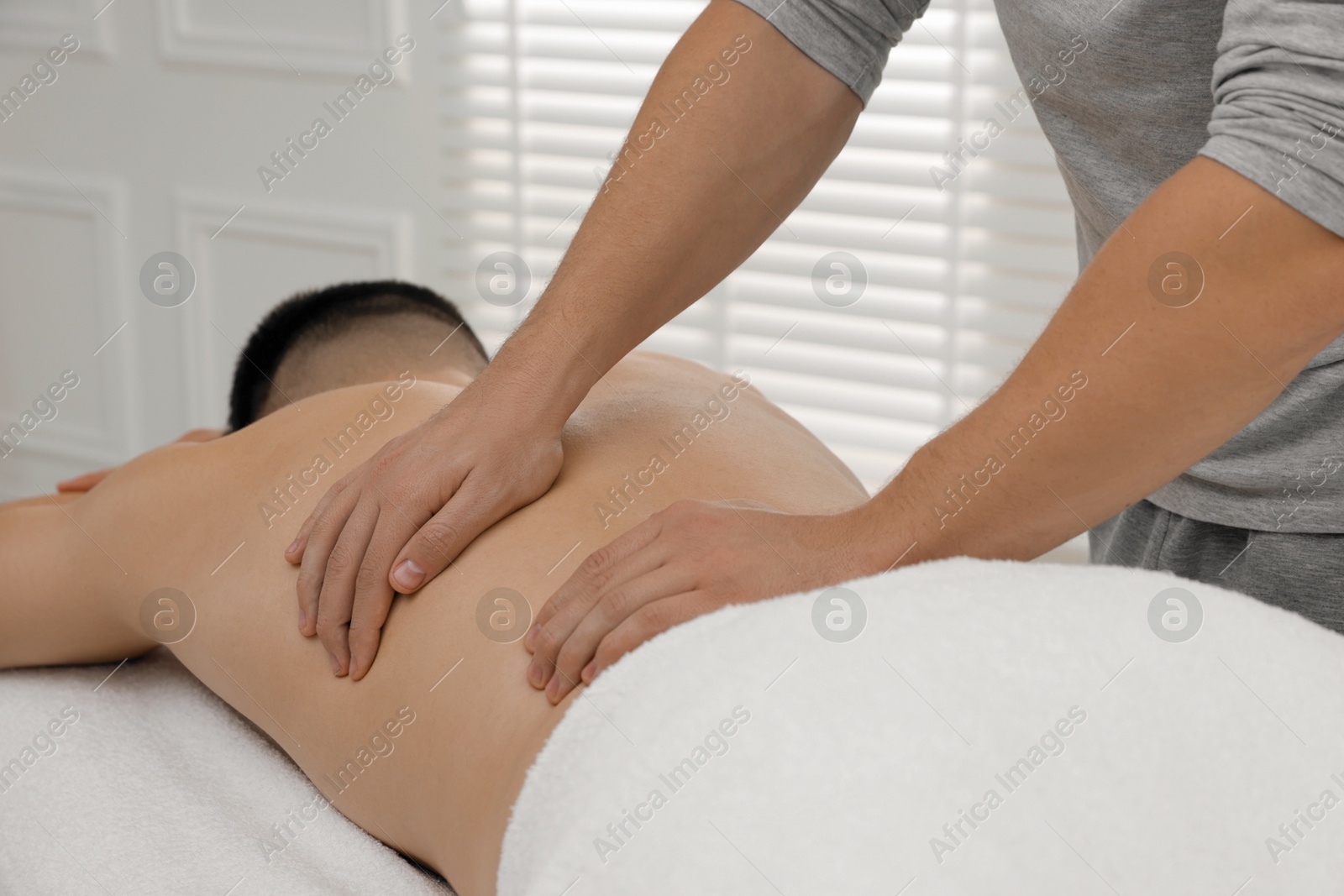 Photo of Massage therapist working with patient in clinic, closeup