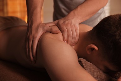 Massage therapist working with patient in clinic, closeup