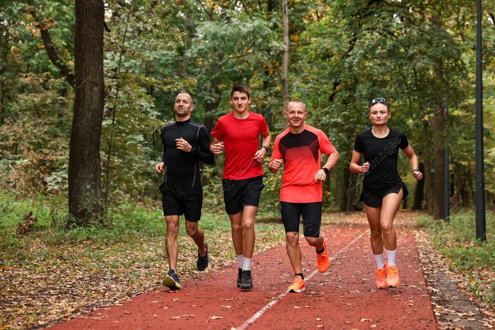 Photo of Group of people jogging together in park