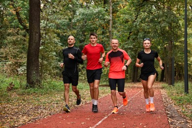 Photo of Group of people jogging together in park