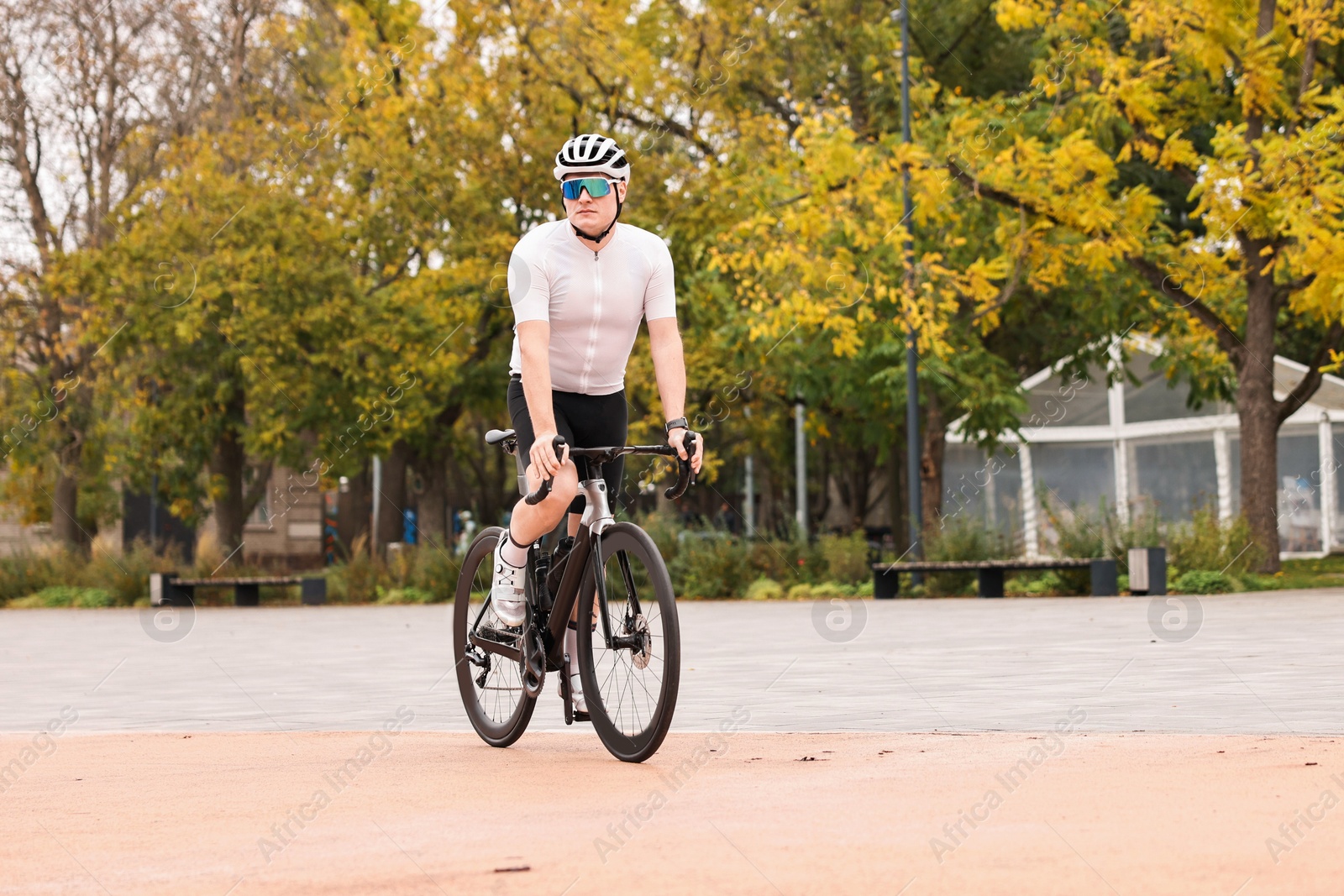 Photo of Athletic man with helmet riding bicycle outdoors