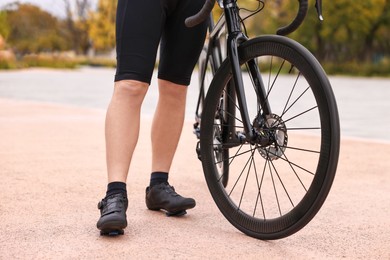 Photo of Athletic man with bicycle outdoors, closeup view