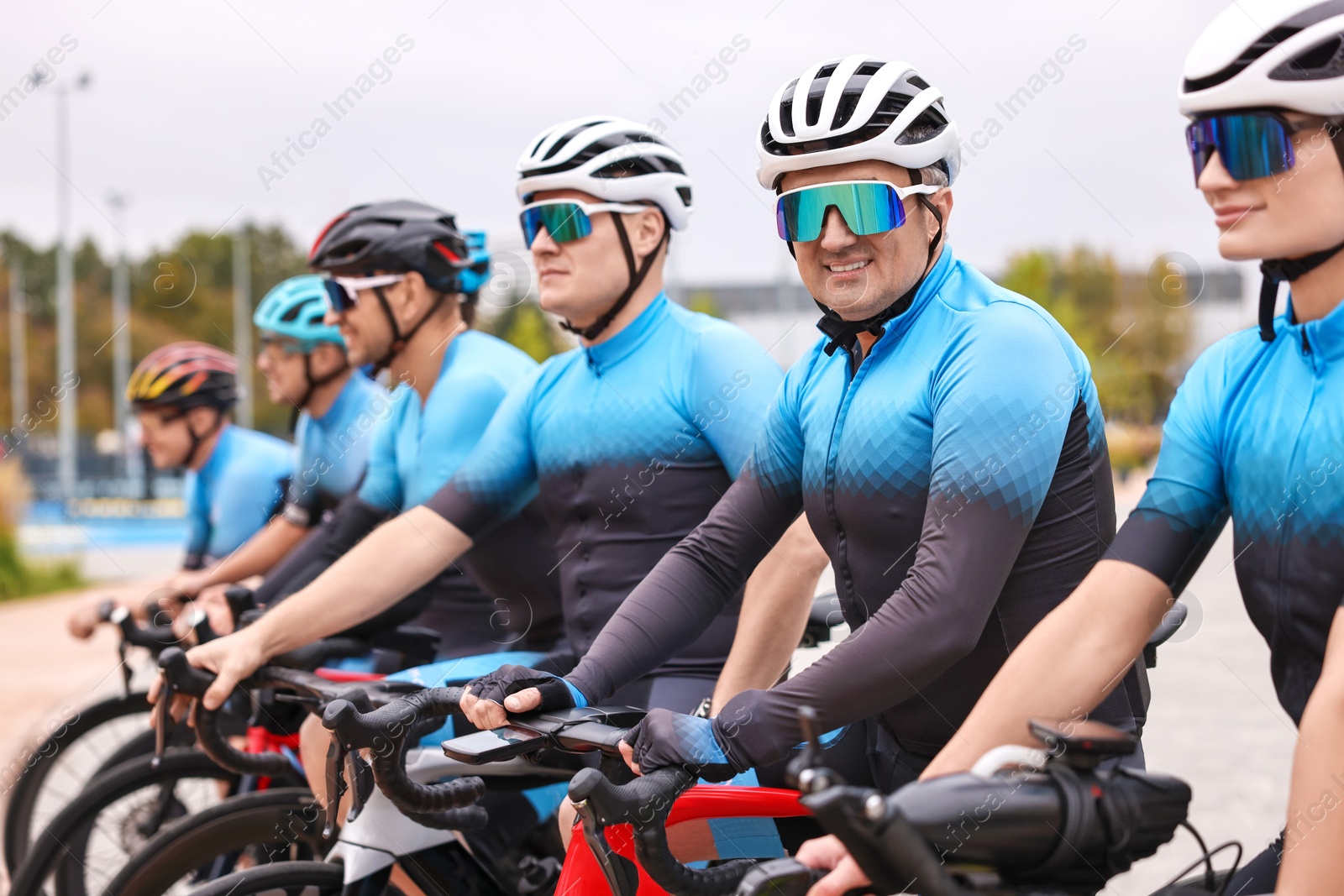 Photo of Group of athletic people with bicycles outdoors