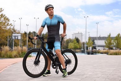 Photo of Athletic man with helmet and bicycle outdoors