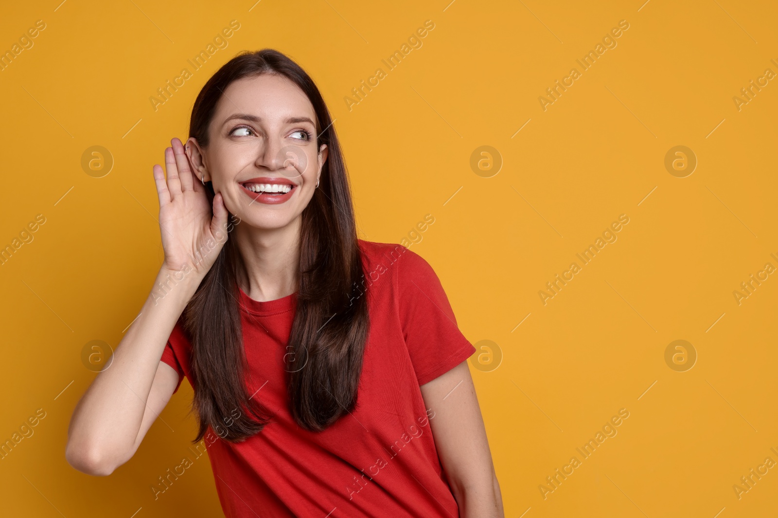 Photo of Woman showing hand to ear gesture on orange background, space for text