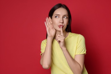 Photo of Woman showing hand to ear gesture on red background, space for text