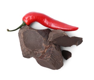 Photo of Pieces of tasty chocolate with chili pepper isolated on white, top view