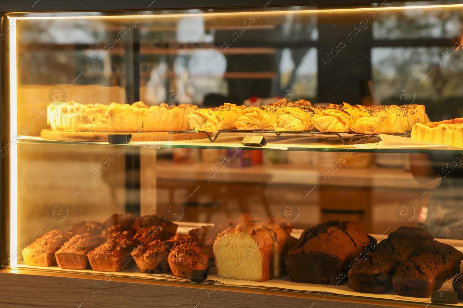 Photo of Different delicious pastries on display in cafe