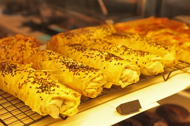 Photo of Tasty puff pastries on display in cafe, closeup